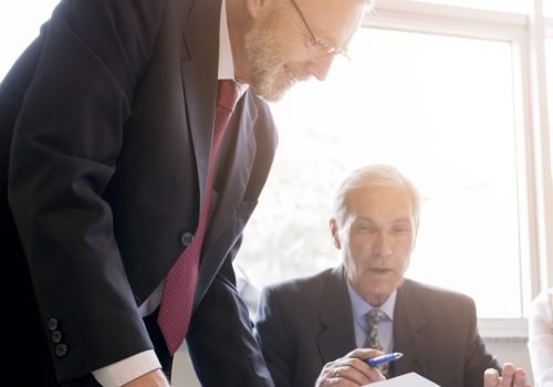 two-senior-businessman-discussing-document-office (1)